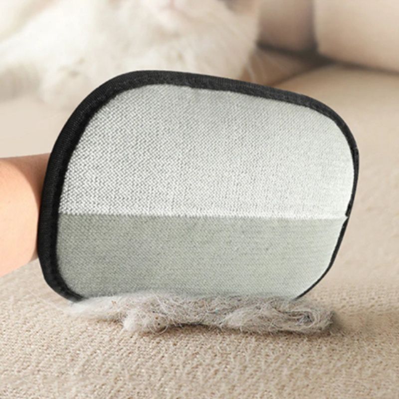 Brosse à chat NovaGlove™ en action sur un tissu clair pour enlever facilement les poils de chat