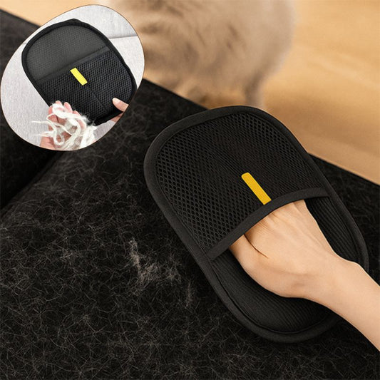 Brosse pour chat NovaGlove™ retirant une grande quantité de poils de chat incrustés sur un canapé foncé