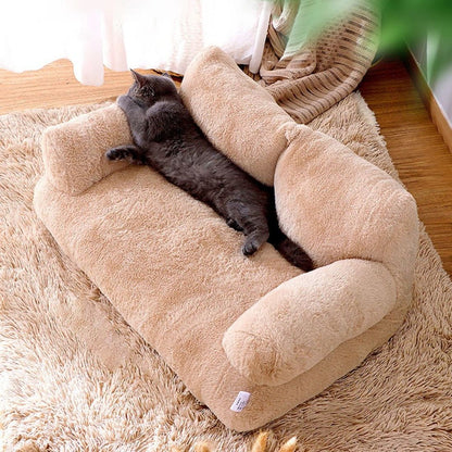 Chat gris étendu de tout son long sur un coussin en forme de canapé beige