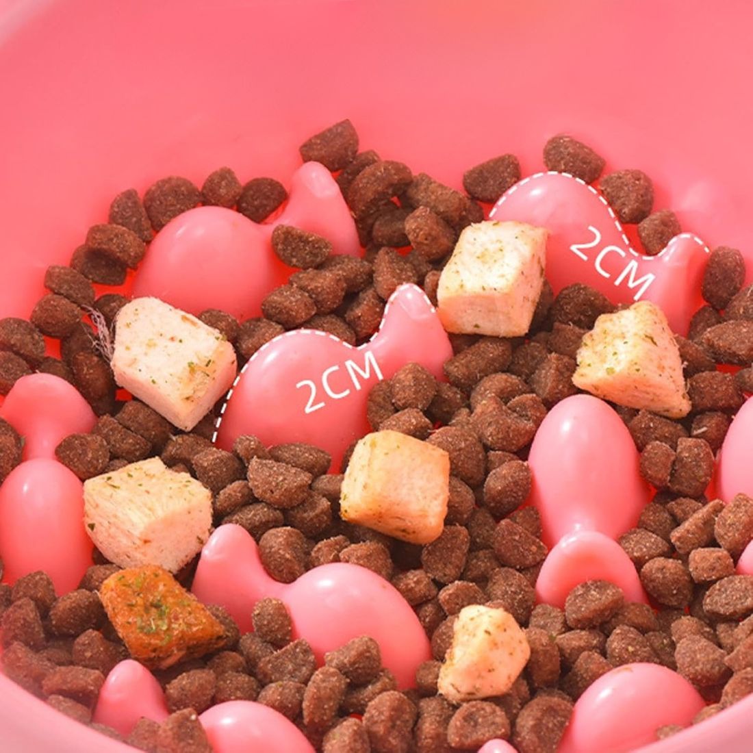 Gros plan de croquettes et friandises dans une gamelle anti-glouton rose ErgoLick - gamelle anti glouton chat ErgoLick