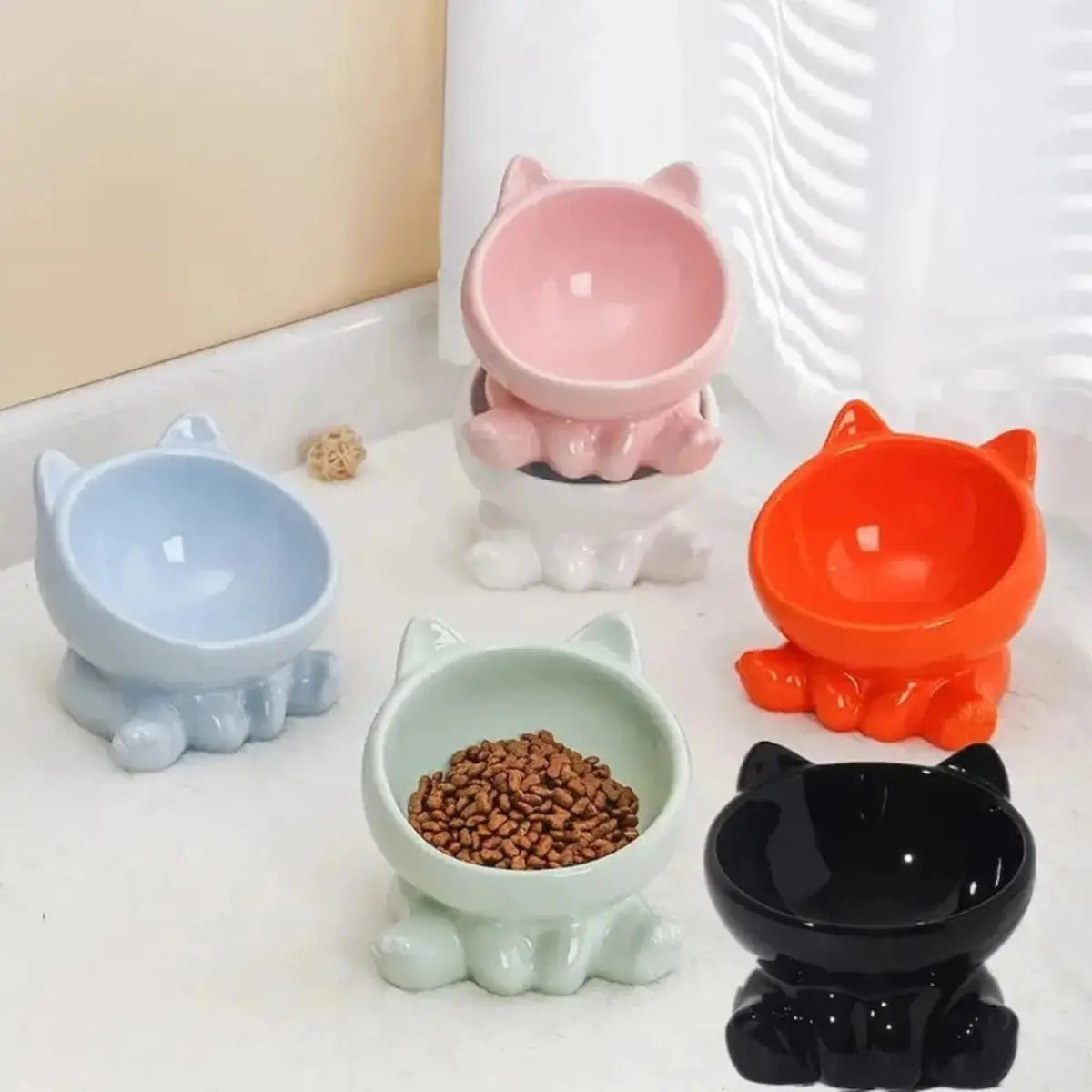 gamelle pour chat Cutie collection multicolore, plusieurs bols inclines en ceramique sur plan de travail.
