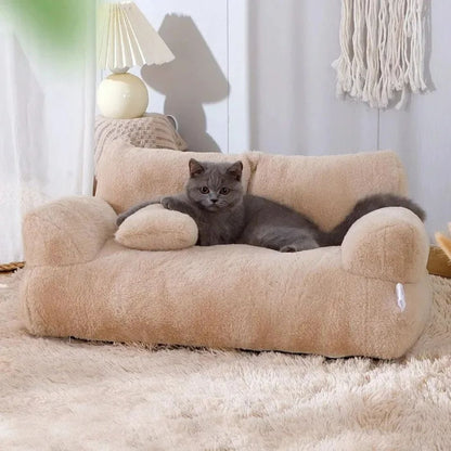Chat gris allongé dans un panier en forme de canapé beige sur tapis moelleux