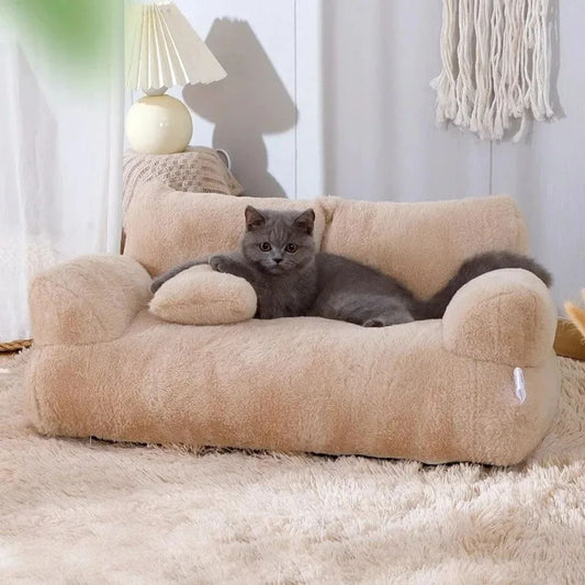 Chat gris allongé dans un panier en forme de canapé beige sur tapis moelleux