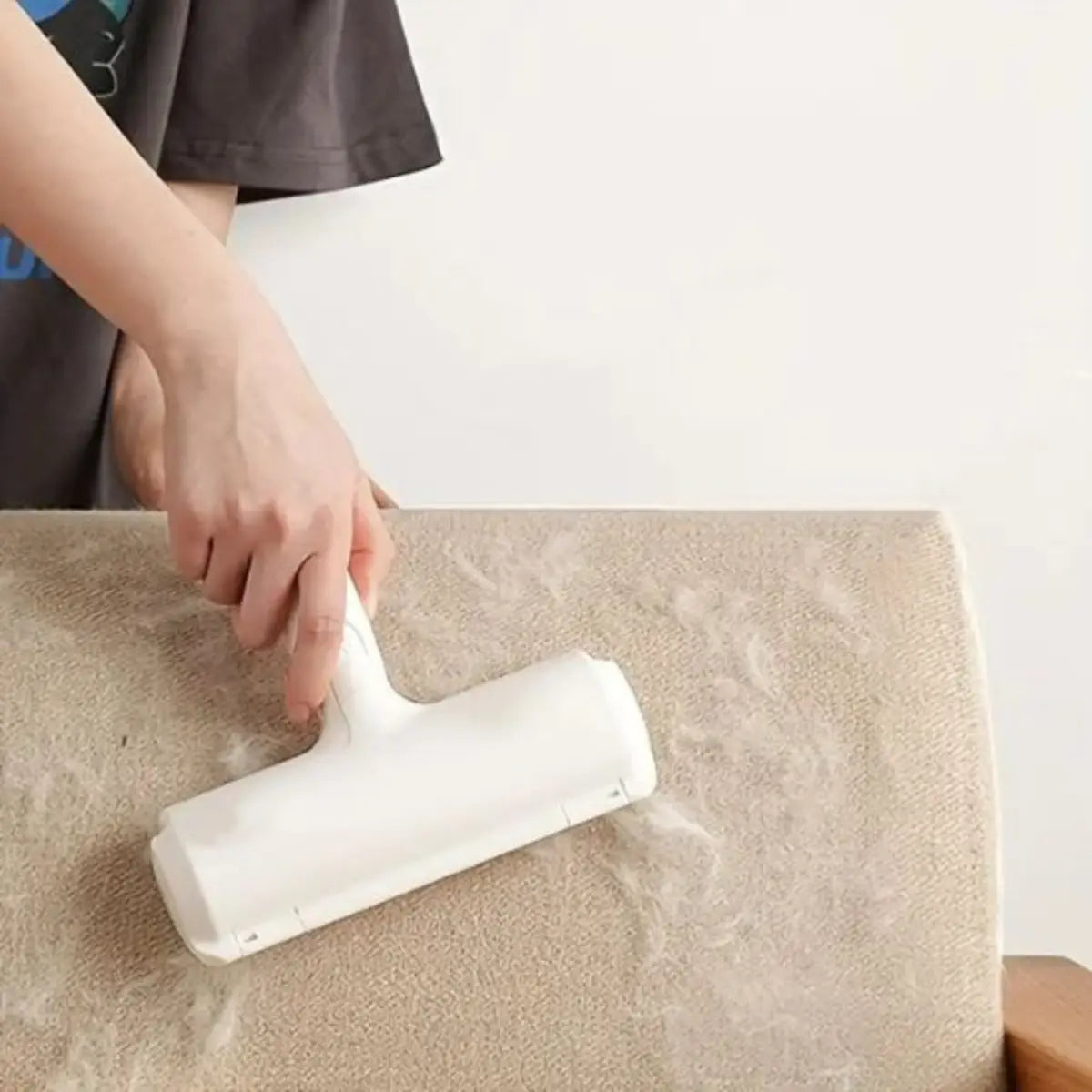 rouleau anti poil pour éliminer efficacement les poils d'animaux sur un canapé beige