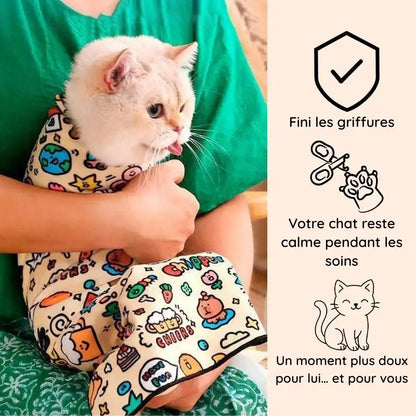 chat blanc enveloppé dans Cocooni pendant le toilettage chat et la coupe des griffes