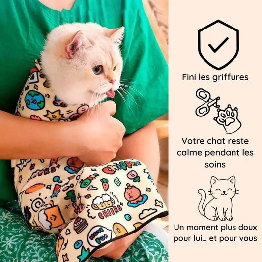 chat blanc enveloppé dans Cocooni pendant le toilettage chat et la coupe des griffes